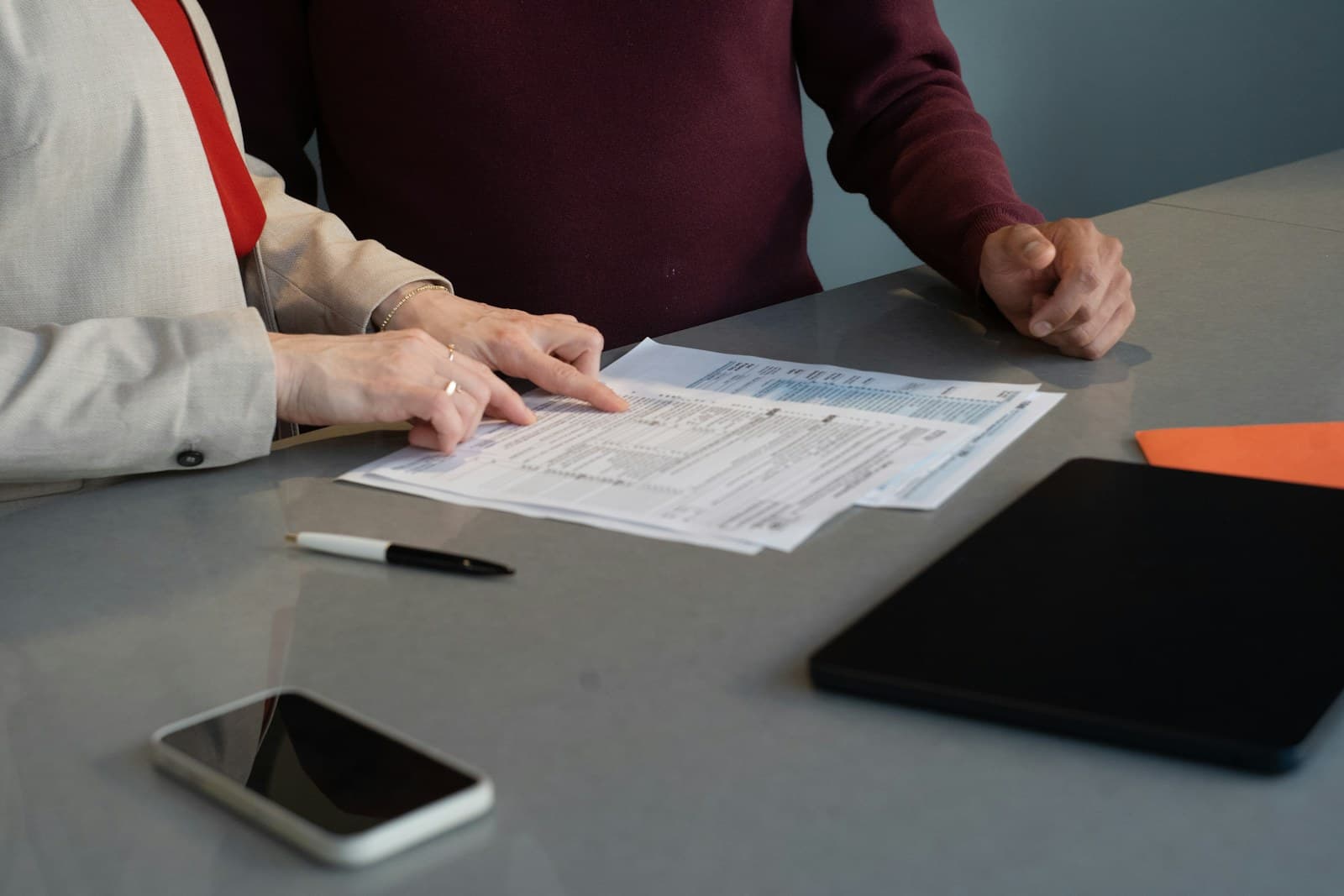 Two advisers reviewing finance documents at a meeting table